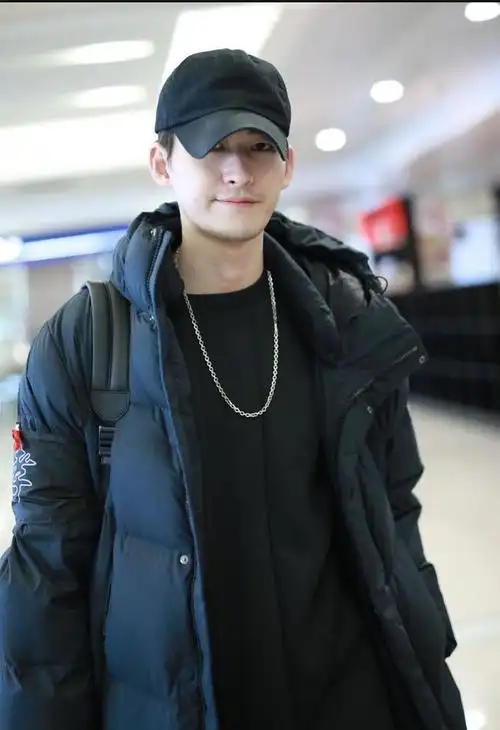 张翰身穿黑色长款羽绒服内搭黑色卫衣现身机场颜值在线精致帅气