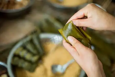 手包粽子端午节一个人室内手工摄影图配图