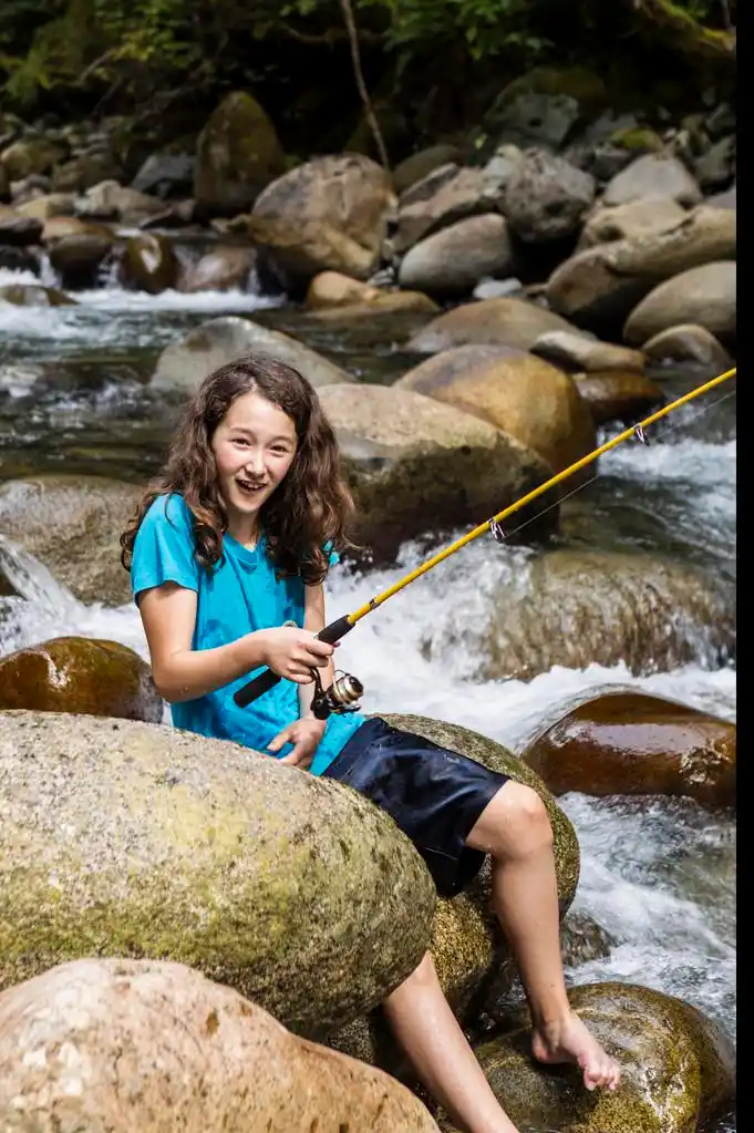 赤脚捕鱼,年轻的女孩,在暑假期间在树林里流赤脚钓鱼很开心