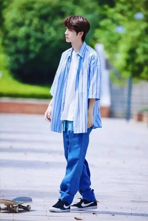 王一博这次穿着一件白t恤 蓝色条纹衬衫,宽松的版型,舒适又不失时尚