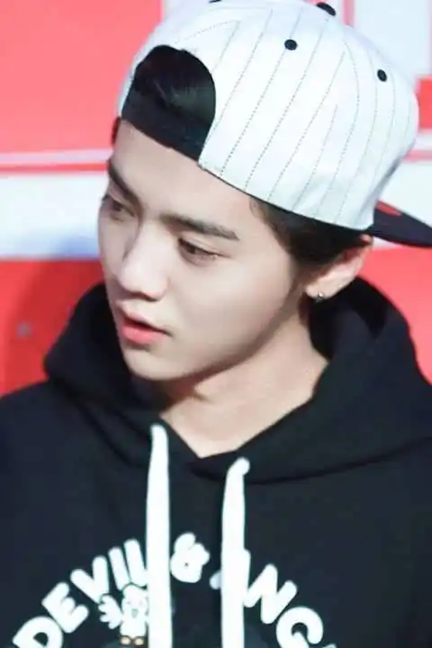 鹿晗穿着黑色卫衣,反戴白色帽子,歪着脑袋,又萌又可爱