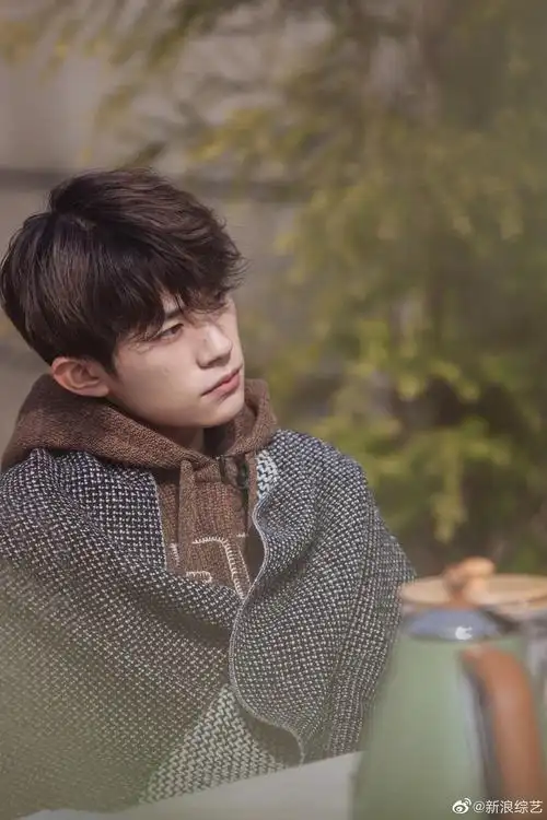易烊千玺穿复古连帽马甲 专注聆听梨涡浅笑文艺范十足