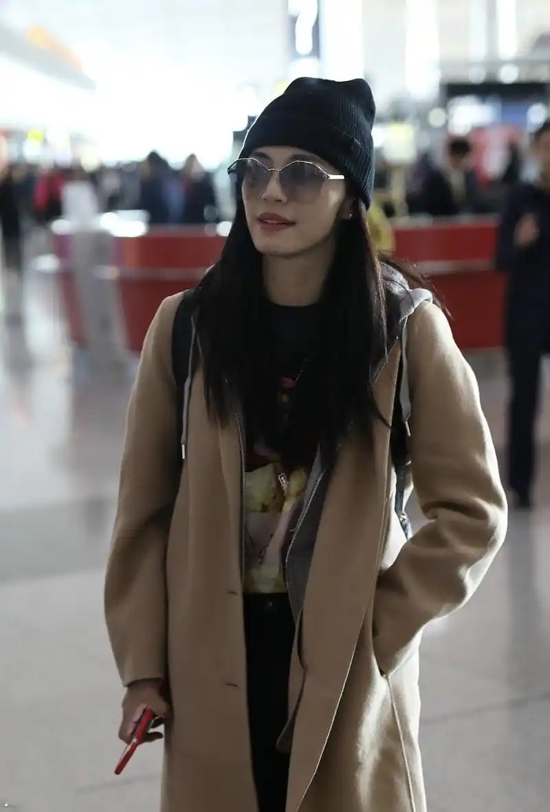 姚晨戴毛线帽和墨镜穿卡其色长款大衣现身机场,皮肤白皙笑容灿烂