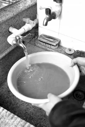 从兴安花苑住户家自来水管流出的自来水呈浑浊状