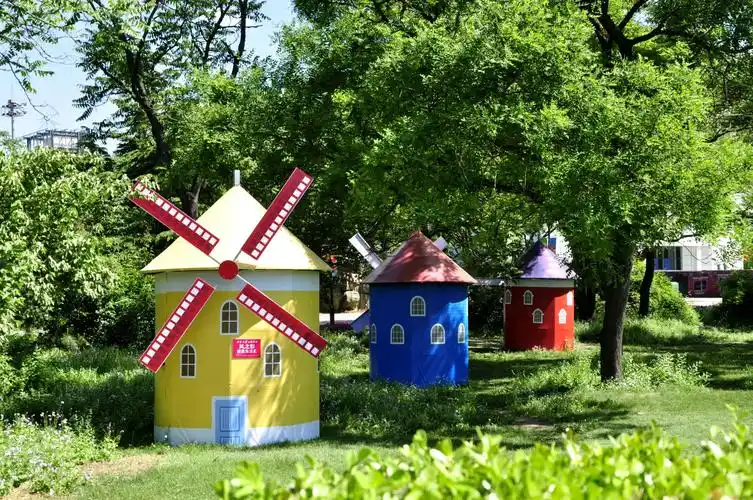 多彩缤纷的风车屋掩映在绿荫中,红蓝黄绿色彩的搭配美妙无比,构成绚丽