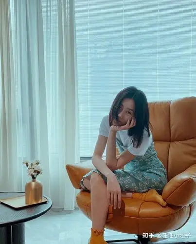 刘雯身着橙红色印花长裙,披肩长发温柔优雅,尽显复古迷人范