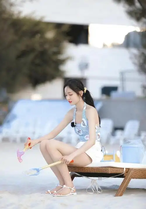 吴宣仪沙滩边录制某节目蓝色挂脖背心配热裤是夏天该有的样子