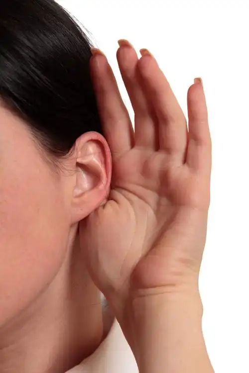 听力的女人,女孩用她的手上一只耳朵听.在白色背景上孤立.