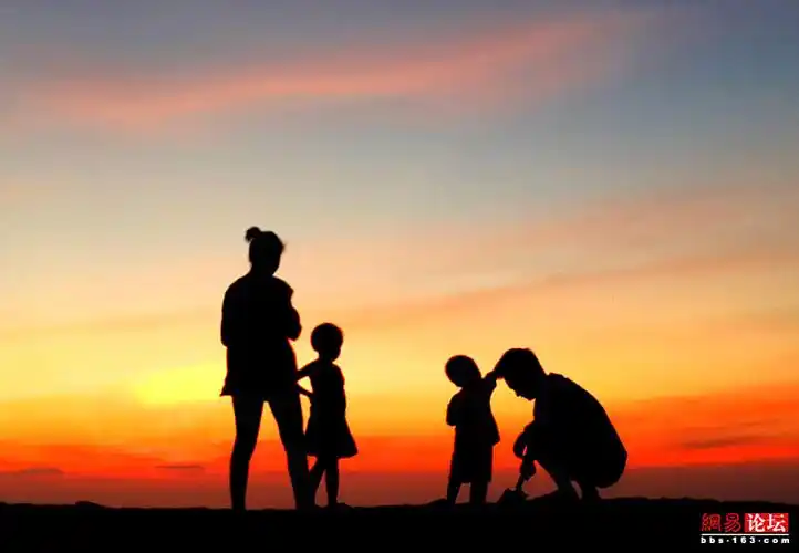 傍晚,在美丽的霞光里,一家四口快乐地在海边游玩,画面剪影所透出的