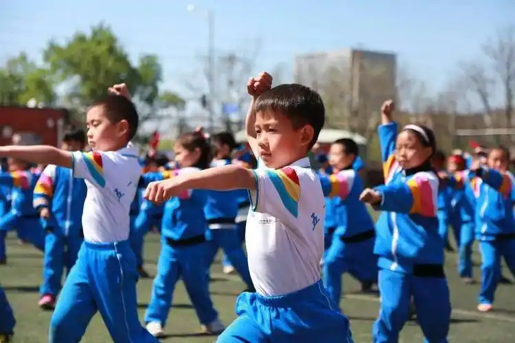随着武术操音乐的轻快节奏,学生们动作整齐划一,标准利落.
