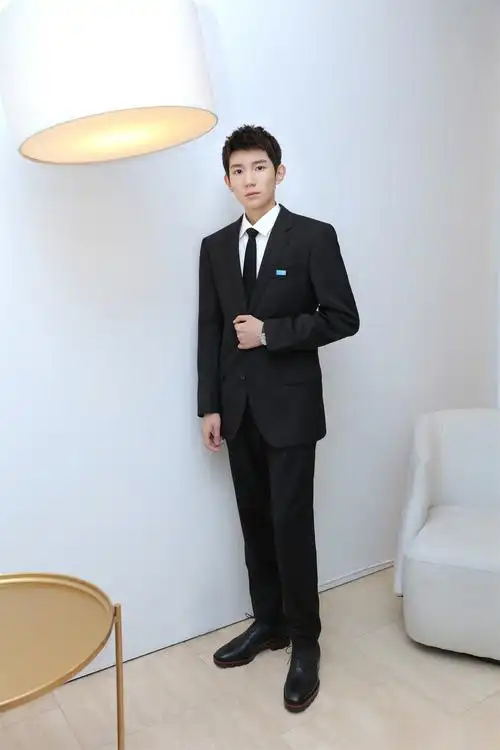 王源身穿黑色竖条纹西装内搭黑色衬衫亮相腾讯音乐娱乐