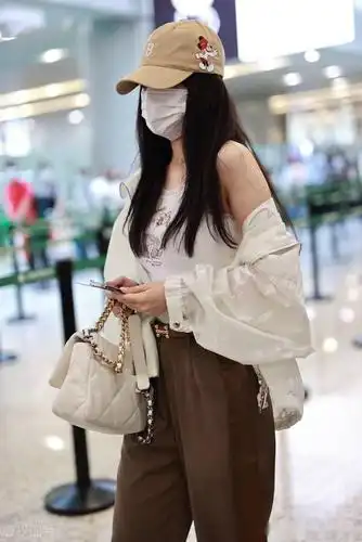 街拍:李小璐穿白色吊带背心宽松长裤大头皮靴个性随意_机场