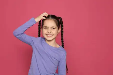 儿童挠头小女孩挠头在彩色背景空间为文本. 烦人的痒照片