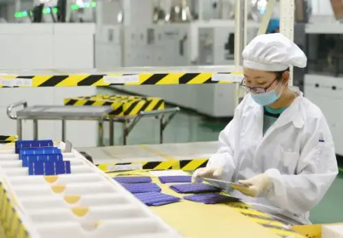 河北保定英利绿色能源控股有限公司的员工在生产车间挑选太阳能电池片