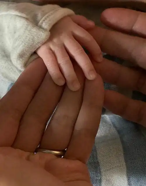 此外,还有一张一家三口叠手照,画面格外温馨.