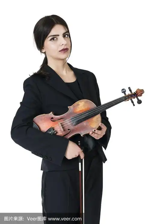 美丽的年轻女小提琴手与小提琴摆姿势
