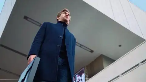 严肃英俊的年轻商人在市区步行上班底部视图