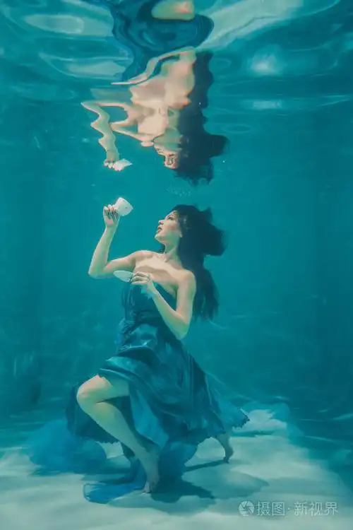享受着乐趣,在早餐时喝着舒缓的茶,同时沉思地穿着裙子在水下游泳