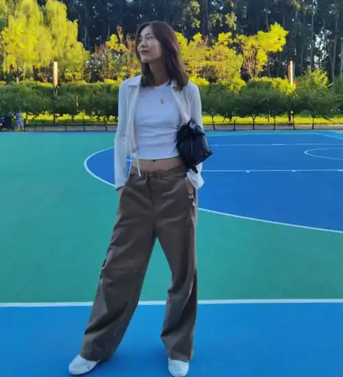 刘雯坐篮球架下秀大长腿,穿白色开衫露纤纤细腰,对镜微笑显温柔