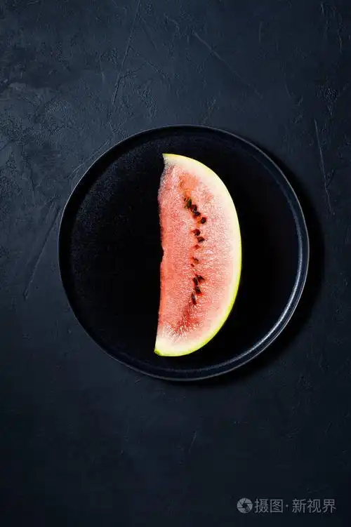 黑色盘子上的一片西瓜深色背景顶部视图