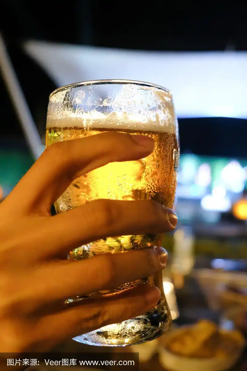 手拿一杯啤酒,背景是白焦