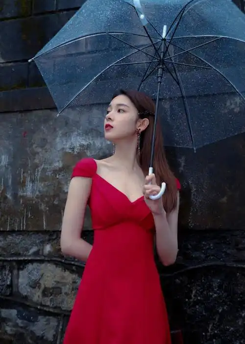 陈瑶身穿红色深v领裙,雨中撑伞眺望远方,这个雨中女子分外柔美