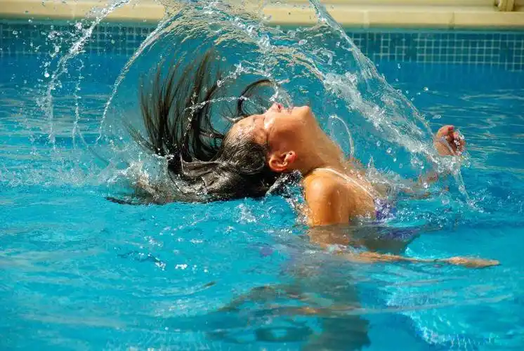 在蓝色泳池里游泳的人