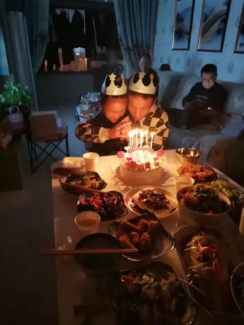 两个孩子坐在一起低头许愿未来更美好