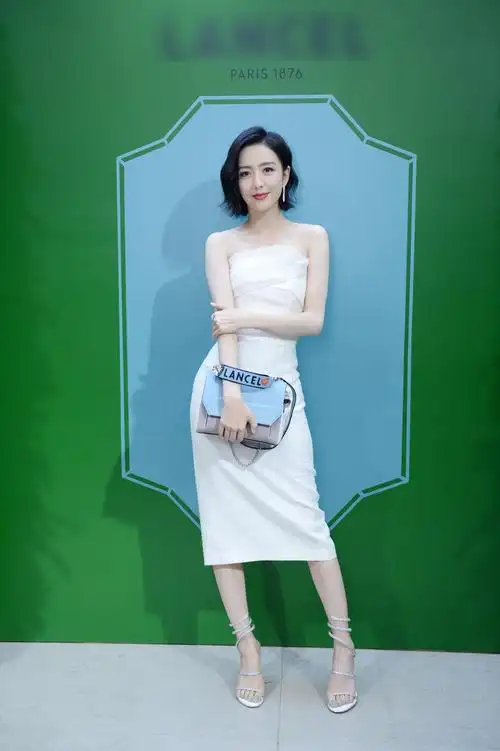 佟丽娅在北京出席品牌活动,她身穿一袭抹胸白裙,脚踩水钻凉鞋,笑容