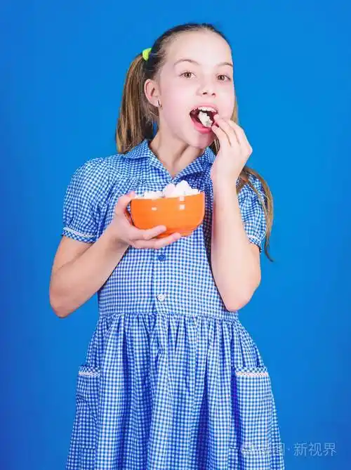 小女孩吃棉花糖节食和卡路里甜食概念快乐的小孩喜欢甜食健康食品和