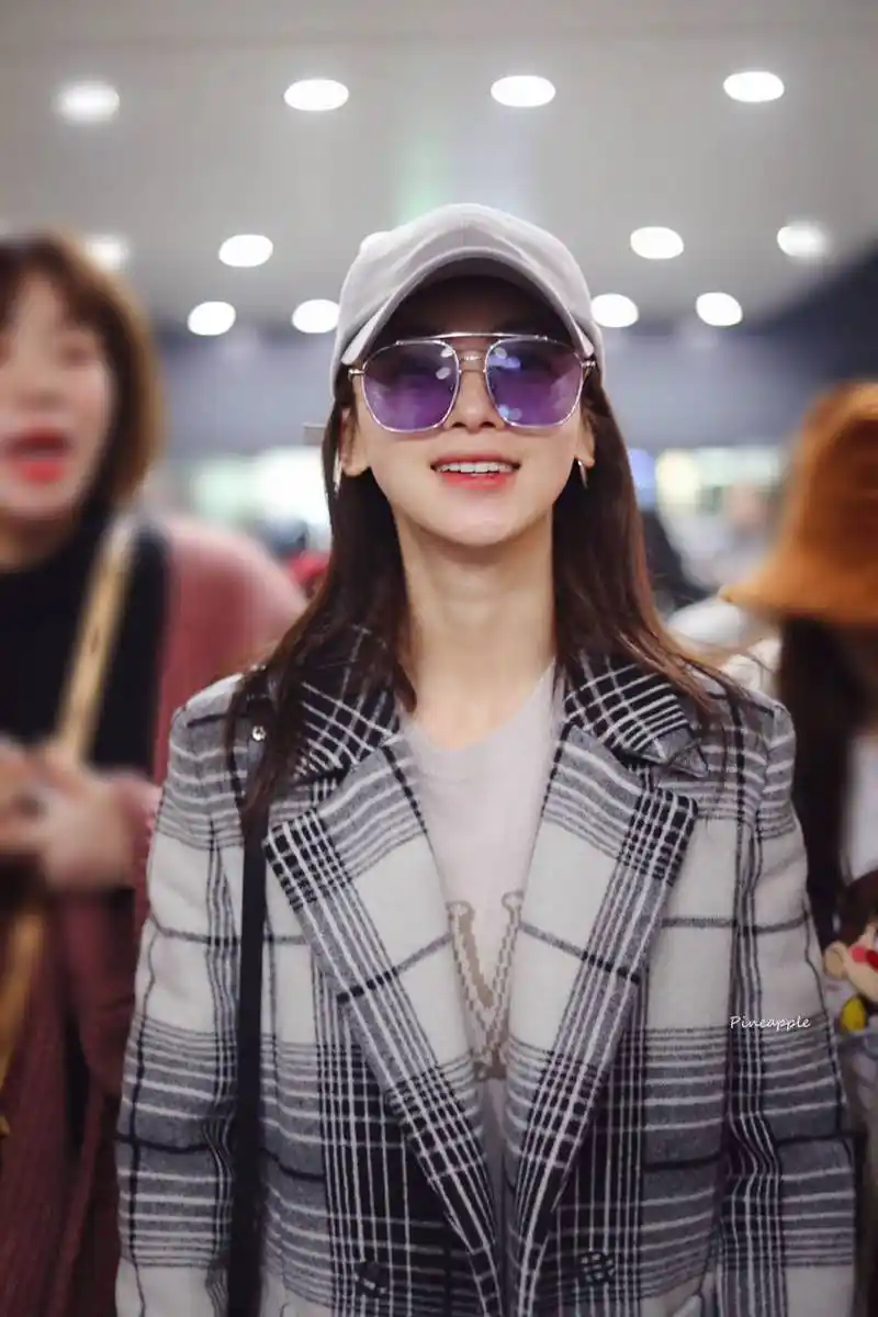 吴谨言戴棒球帽和墨镜穿灰色格子大衣现身机场,皮肤白皙面带微笑