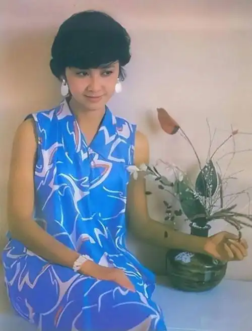 二十几岁时朱琳美的有特色留大波浪穿长风衣脚踩布鞋妩媚灵动