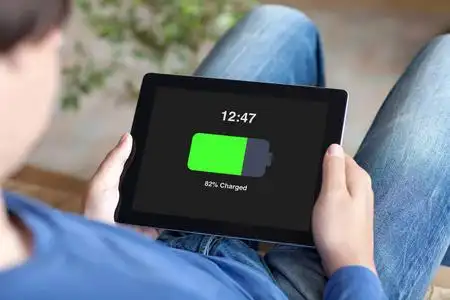 男子手持平板电池在屏幕上充电照片