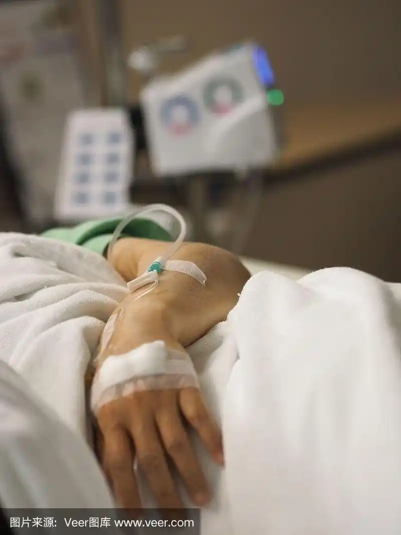 病人睡在病房的床上,在医院女性手上设置静脉注射生理盐水
