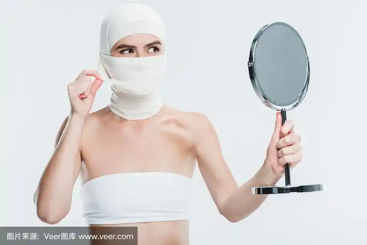 女人用绷带整容后的脸望着镜子上孤立的白色