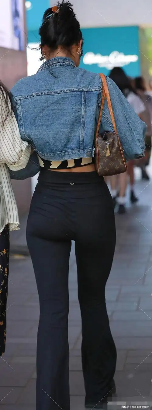 黑色微喇紧身裤搭配牛仔上衣的穿搭展现出女性的美丽与时尚