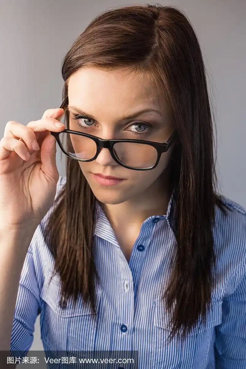 严肃的黑发拿着眼镜摆姿势