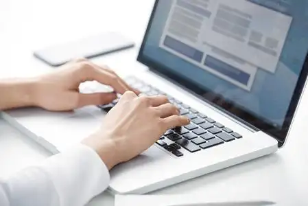 当你坐在办公桌前, 为新项目工作时, 在笔记本电脑键盘上的女商人的手