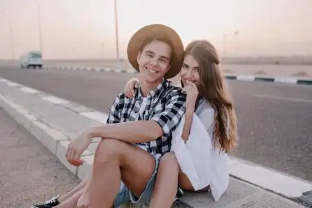 笑容可掬的一对美丽的情侣在背景上与美丽的天空共度时光.照片