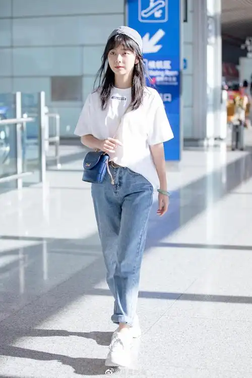 8月27日,谭松韵现身北京机场,burberry白t搭配卷边牛仔裤
