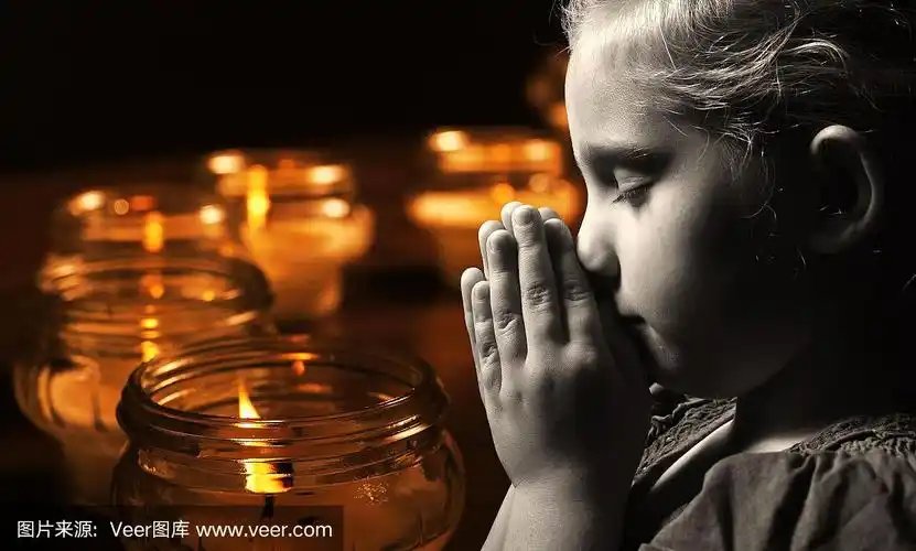 祈祷的孩子用蜡烛做背景.