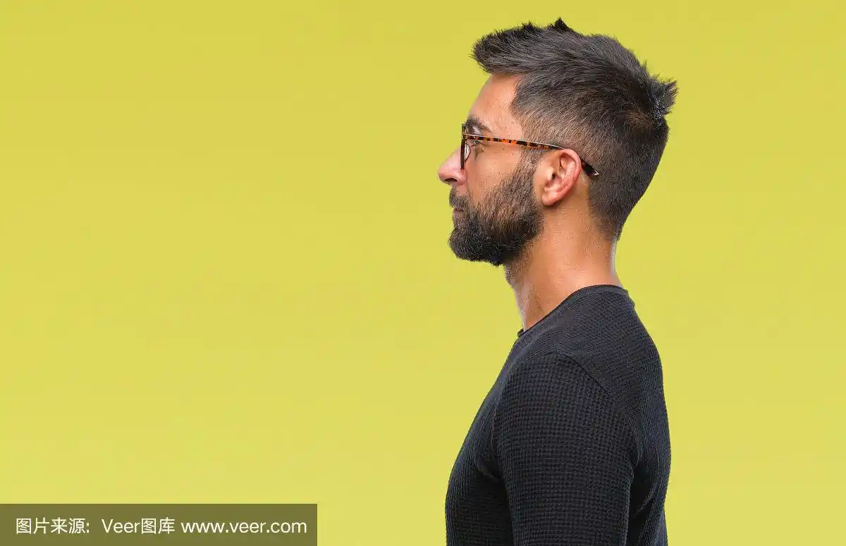 成年西班牙男子戴眼镜孤立的背景看向一边,放松的侧面姿势与自然的脸