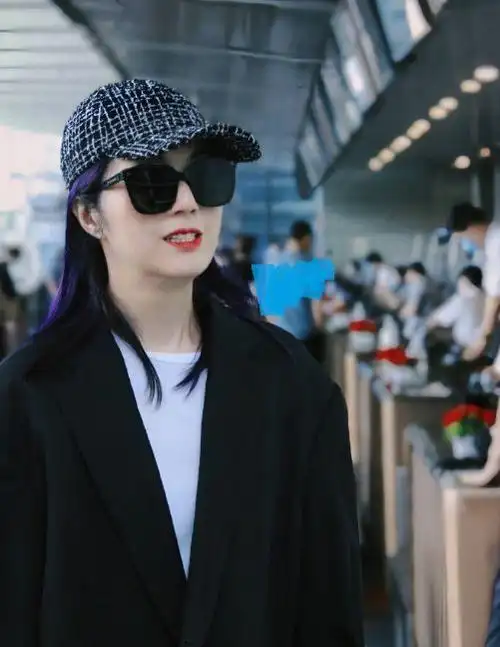 杨千嬅脚踩黑色皮鞋,头戴浅蓝色棒球帽,同时搭配了一款墨镜,把头发染