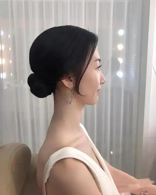 精致的盘发需要先把头发梳理垂顺,然后在发根的位置紧紧地绕圈,这时候