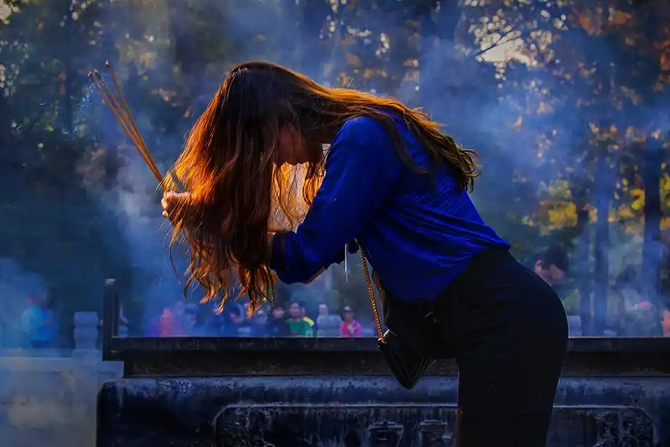 2019年11月23日拍摄于南京栖霞山,女士烧香拜佛