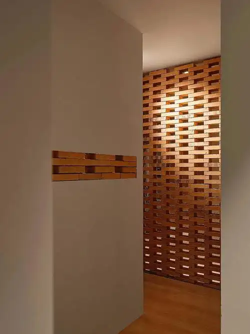 玄关区以红砖砌筑的结构元素充当背景墙镂空错落的排布丰富红砖墙面的