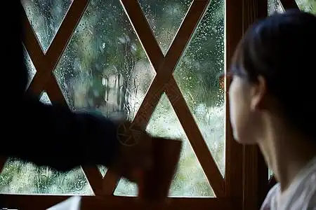 下雨看向窗外的女青年图片素材
