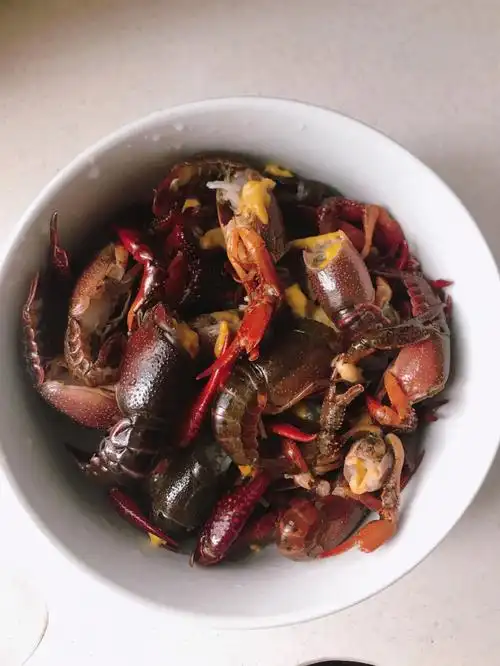 桂皮,八角,花椒,红辣椒,冰糖放入油锅翻炒然后爆炒倒入小龙虾,放上