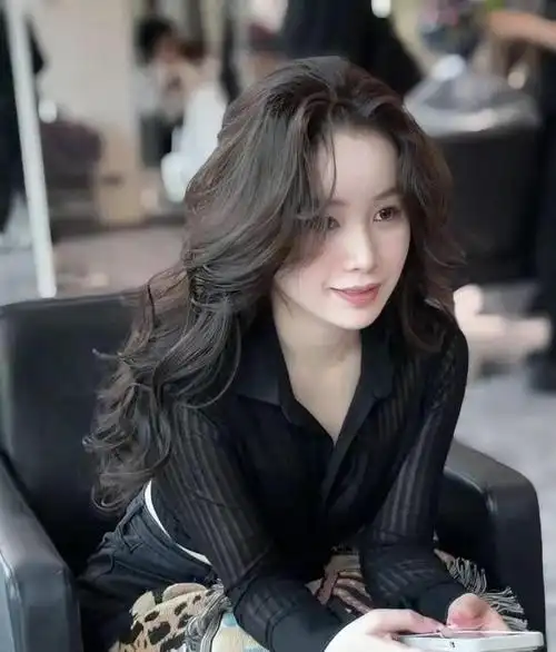 对于50岁女性来说,大波浪烫发不仅可以增加发型的层次感,还能显得头发