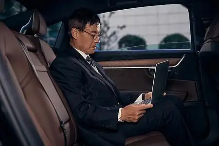 汽车公司图片公司老板坐在轿车后排看电脑背景